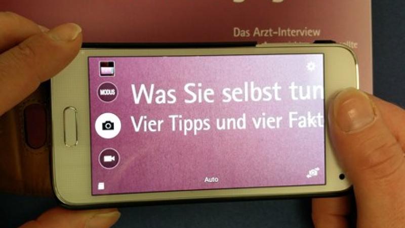 Smartphone mit vergrößertem Ausschnitt eines Textes Kameravergrößerung mit Smartphone