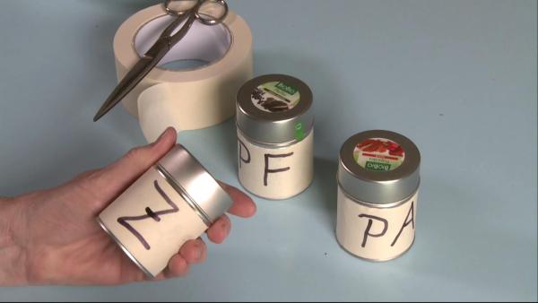 Gewürzdosen mit Krepp beklebt und Buchstaben beschriftet