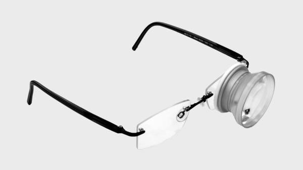 Brille mit eingebautem Fernrohr auf dem linken Glas