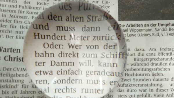 Lupenstein zum Vergrößern aufgelegt auf Zeitungsartikel