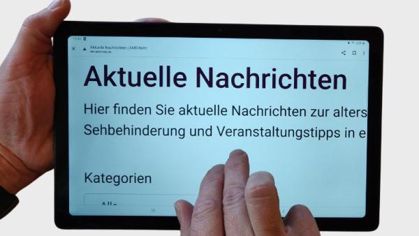 Ein Mann hält ein Tablet auf dem groß 