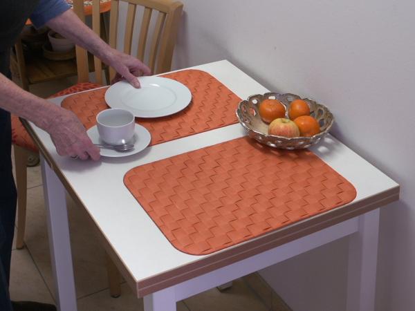 Weißer Tisch mit farbigen Sets und weißem Geschirr