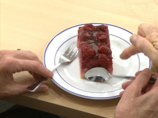 Mit Gabel und Löffel ein Stück Kuchen essen
