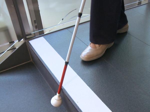 Mit dem Blindenlangstock eine Treppenstufe ertasten