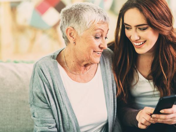 Jüngere Dame erklärt Seniorin die Smartphonenutzung