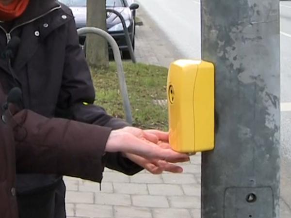 Gelber Blindensignalgeber, der am Ampelmast angebracht ist