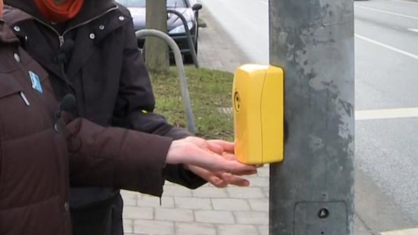 Gelber Blindensignalgeber, der am Ampelmast angebracht ist